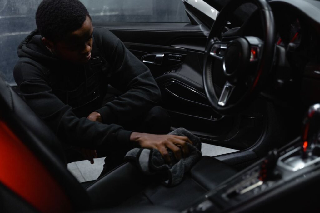 Crafting Captivating Headlines: Your awesome post title goes here A man wipes the interior of a car for a thorough cleaning, focusing on detailing and maintenance.